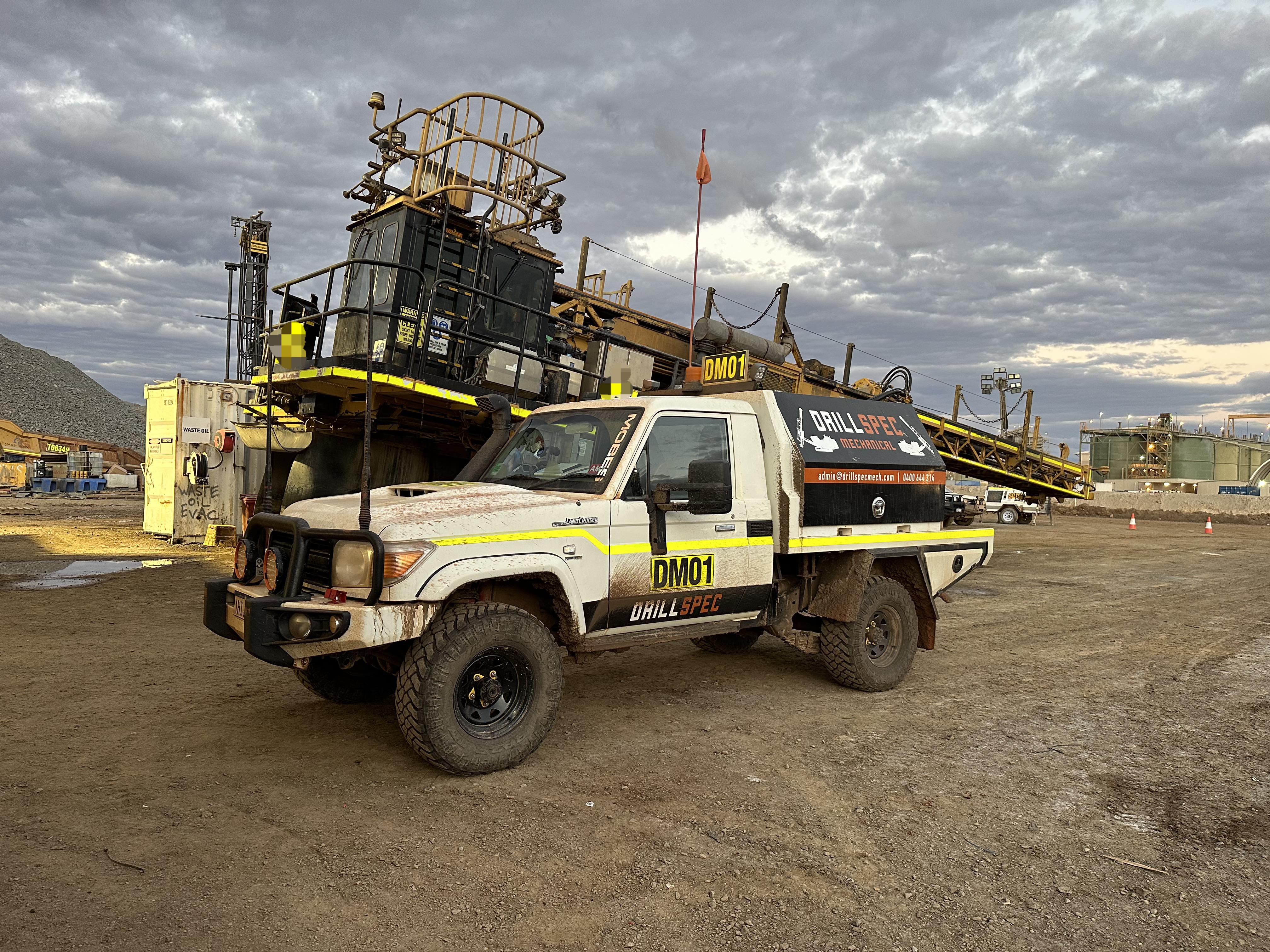 Drillspec DM01 service ute alongside surface drill rig at dusk