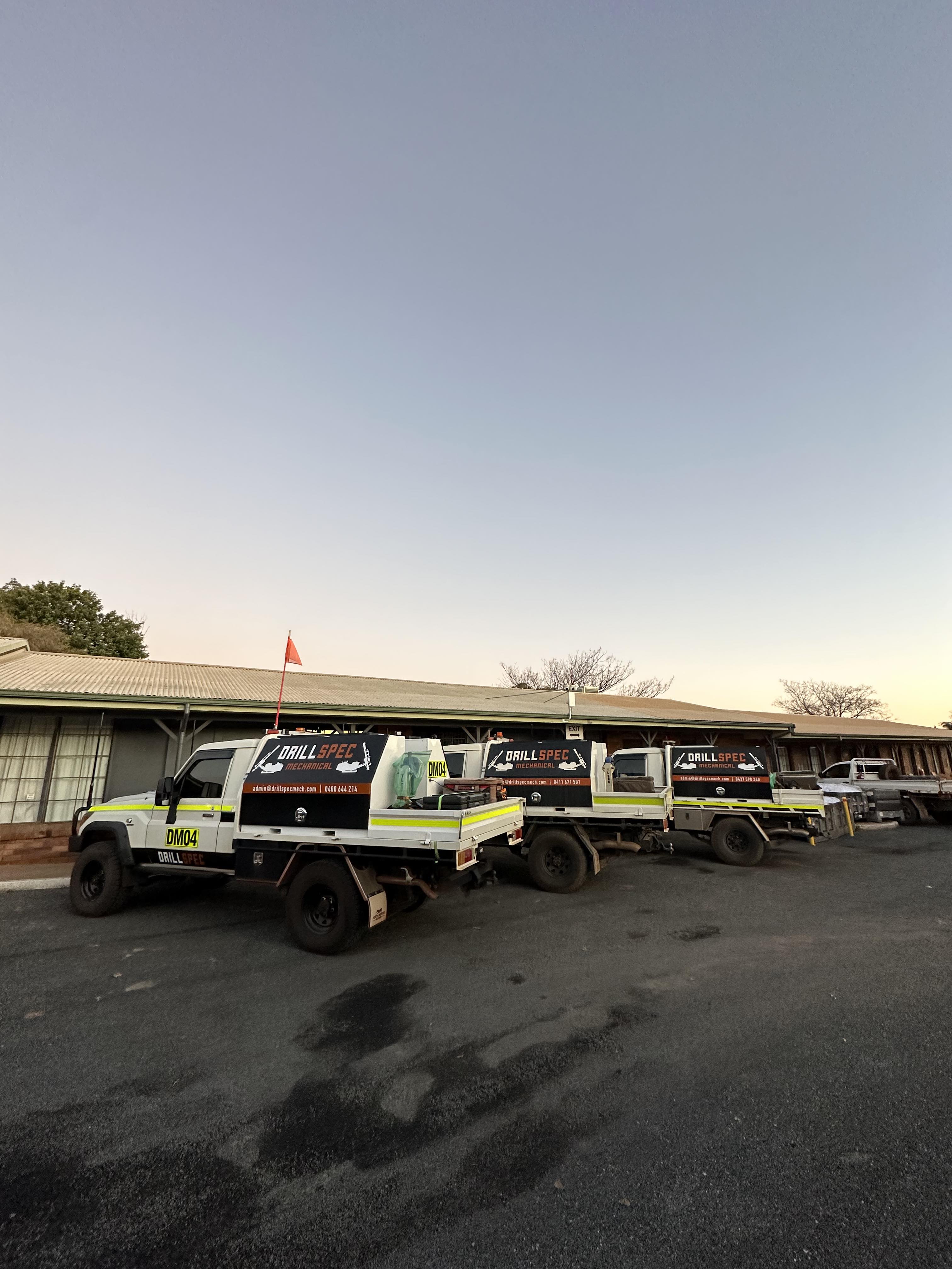 Drillspec service ute fleet lined up at the workshop yard at dusk