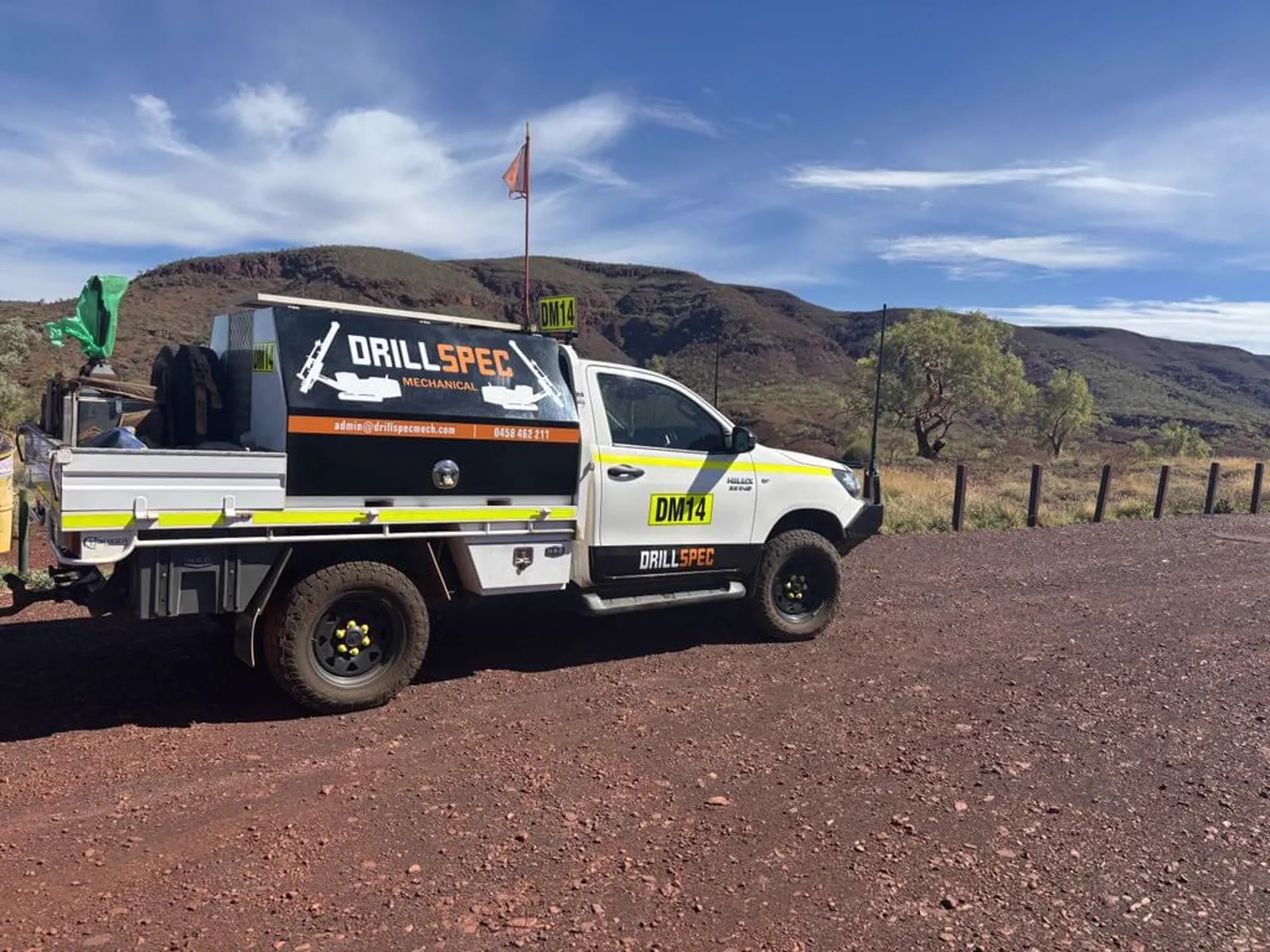 Drillspec service ute beside a surface drill rig at golden hour