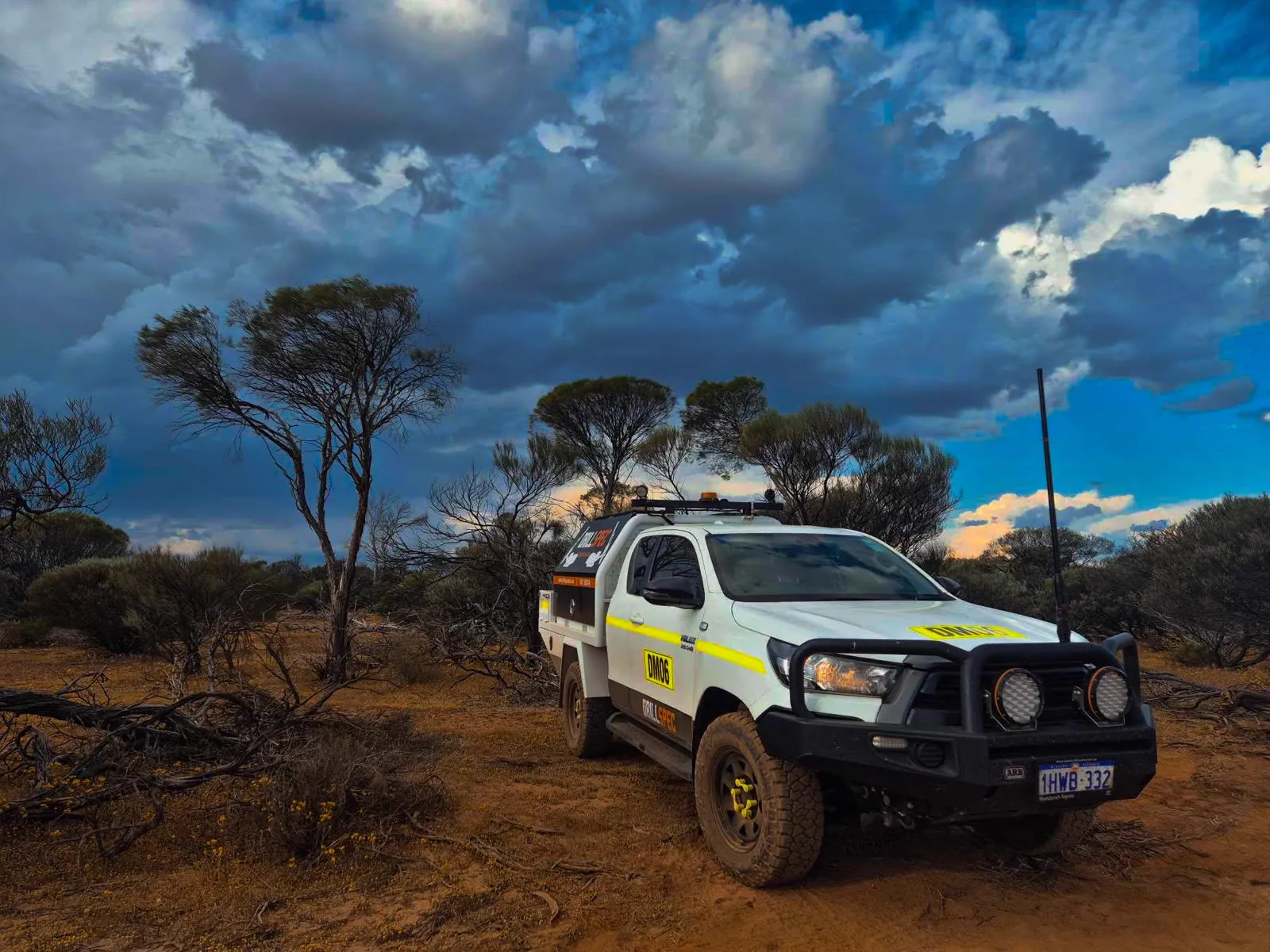Drillspec ute on a bush track with storm clouds building