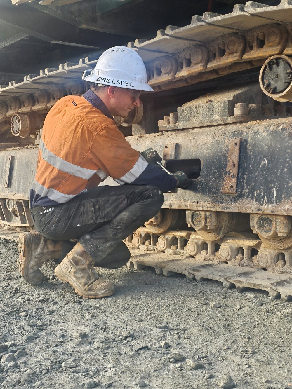 Drillspec technician inspecting an excavator track frame