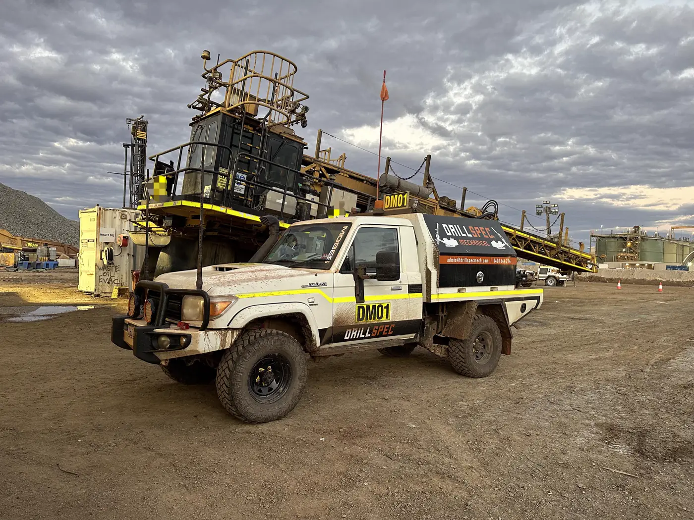 Drillspec DM01 service ute alongside surface drill rig at dusk