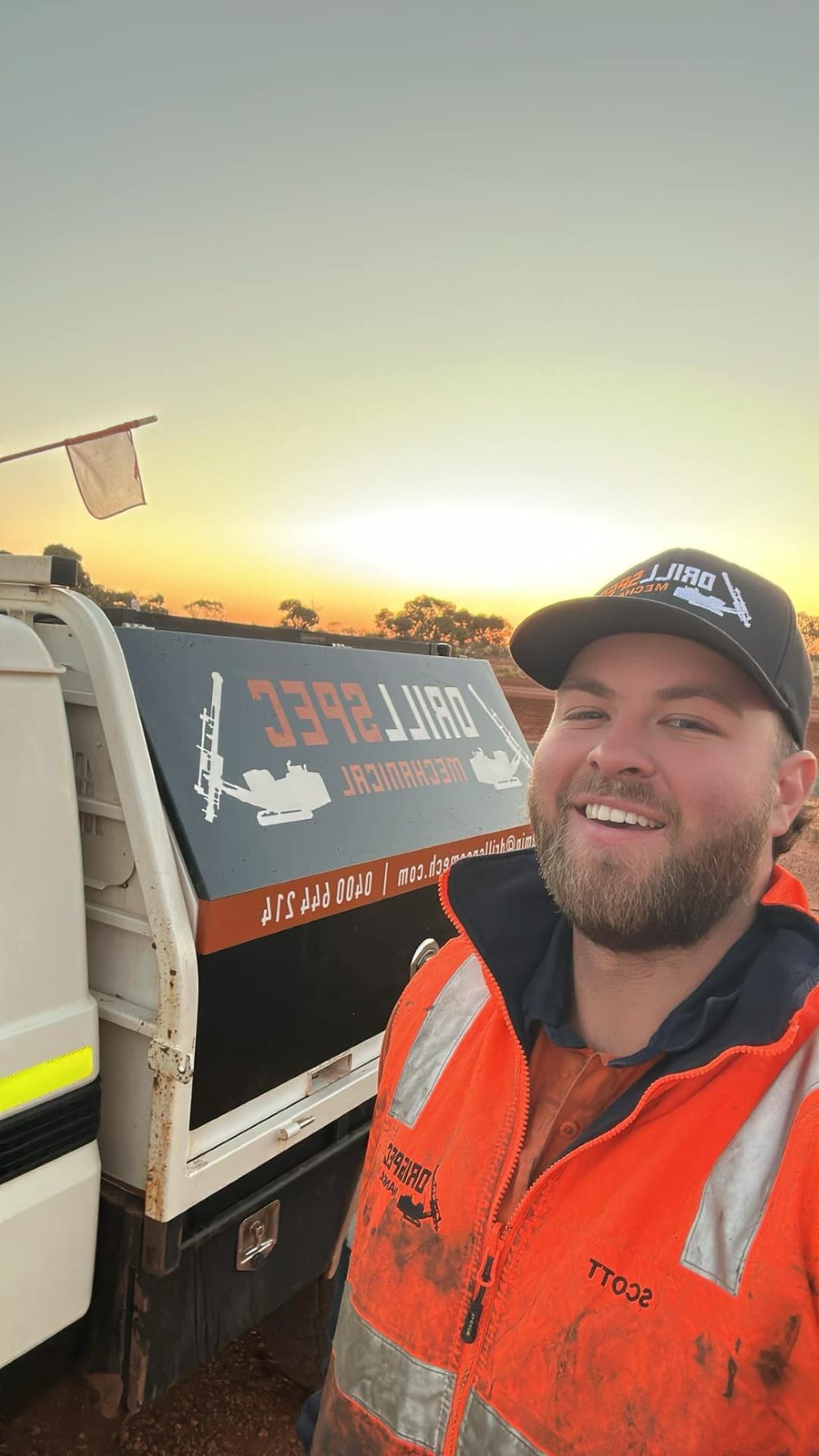 Drillspec field-service tech Scott in hi-vis beside the DM service ute at sunset