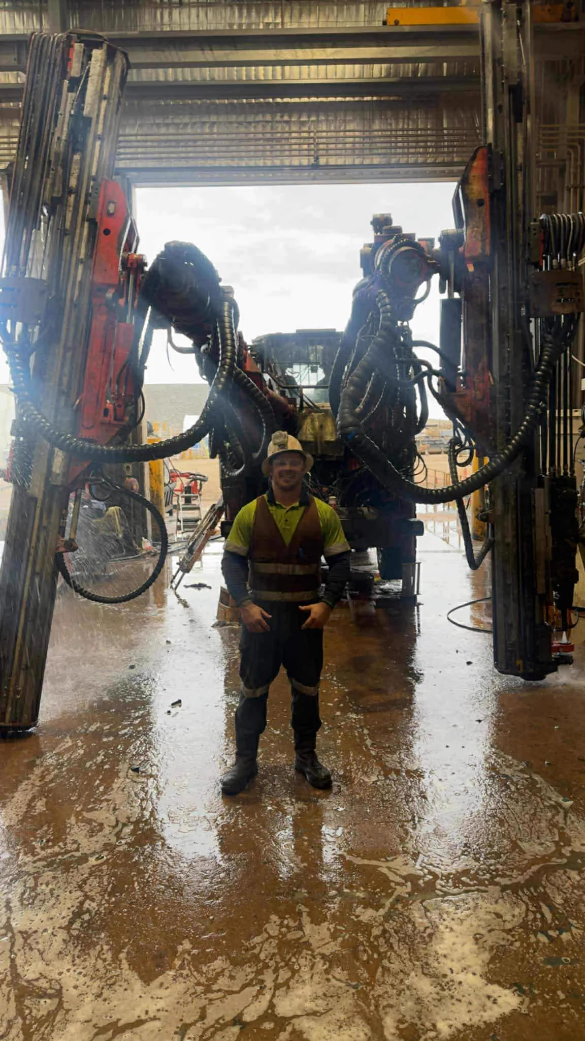 Drillspec mechanic standing in front of a drill rig in for service