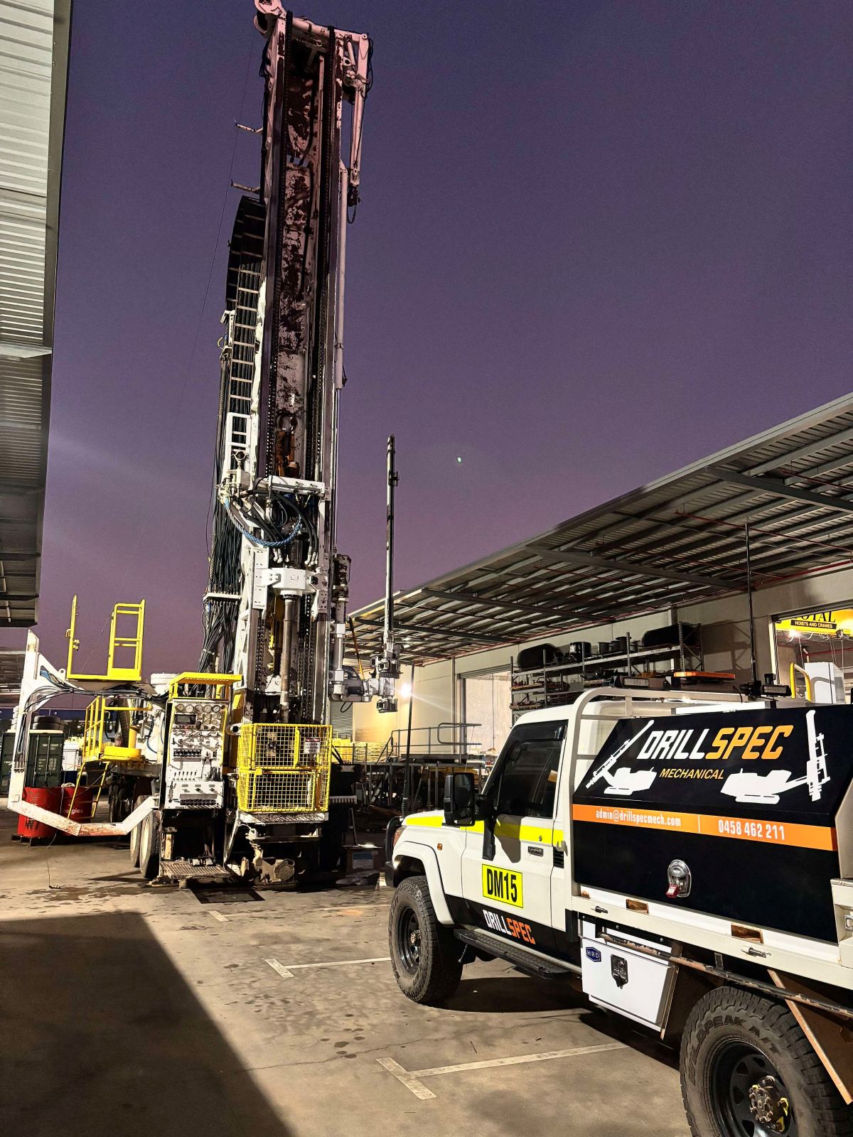 Underground jumbo drill rig and Drillspec DM15 ute at twilight