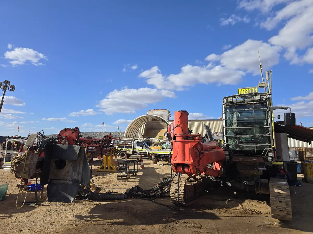 Sandvik Leopard DR3171 mid-strip in the shut laydown, boom and mast components staged on stands