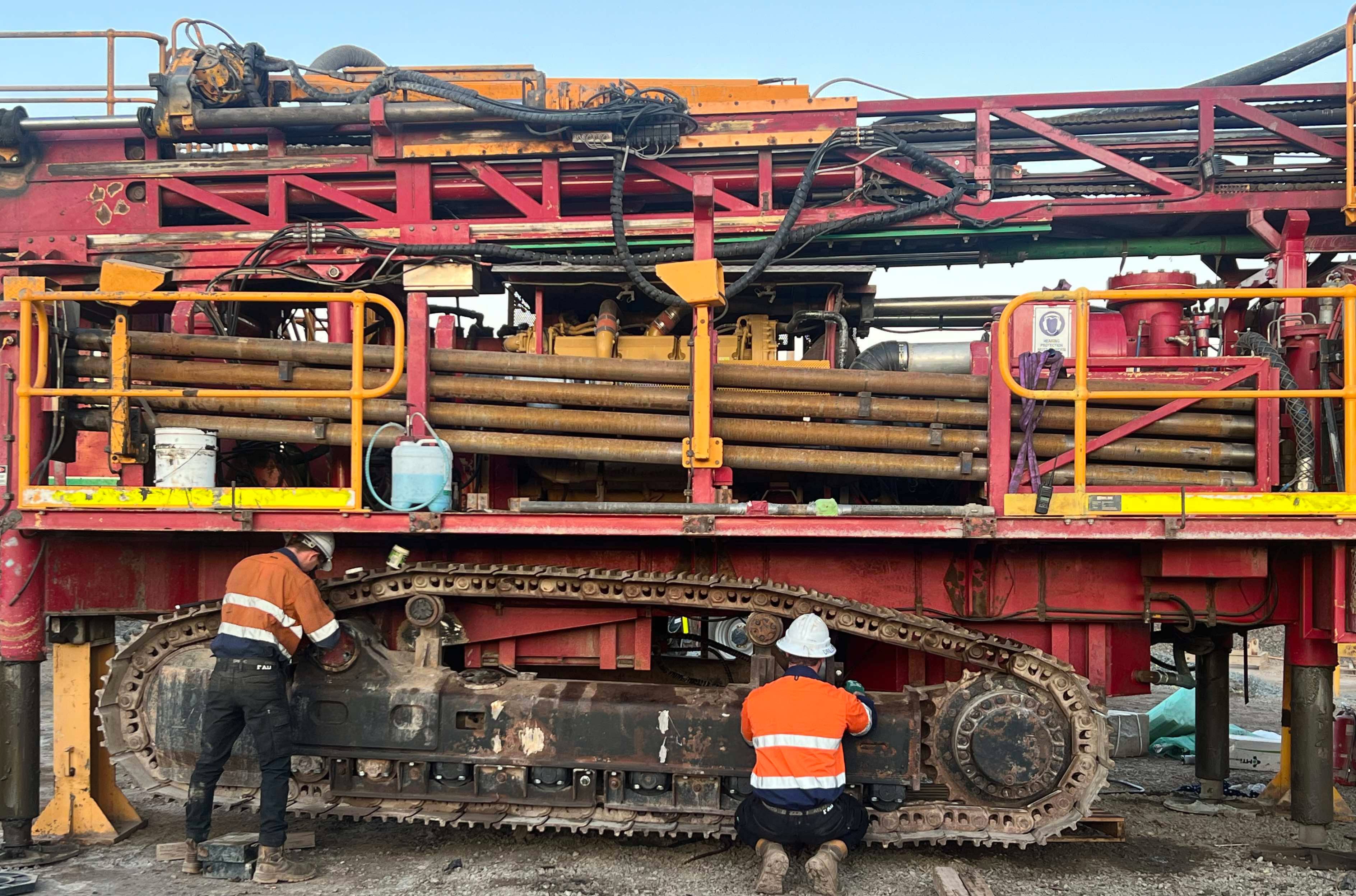 Two Drillspec techs servicing the tracks of an underground drill rig